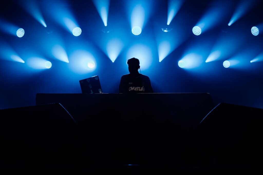 silhouette of a dj at a concert with blue lighting