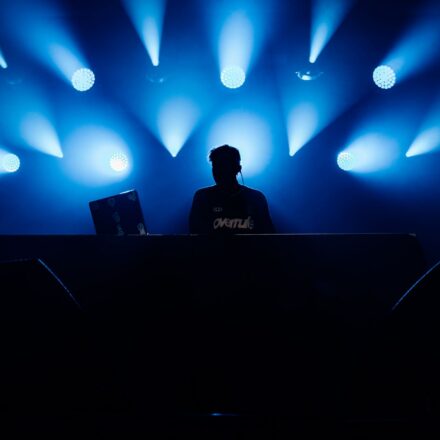 silhouette of a dj at a concert with blue lighting